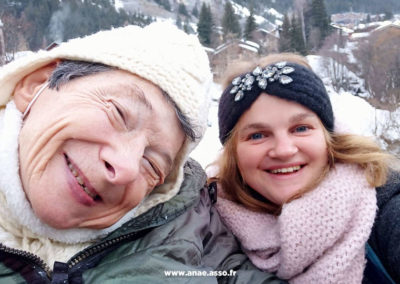 Une vacancière heureuse et son accompagnatrice lors d'un séjour adapté handicap moteur à la montagne